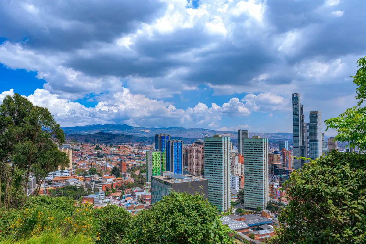 Vista aérea de Bogotá extendiéndose hasta el horizonte desde las laderas de Monserrate, con el teleférico visible