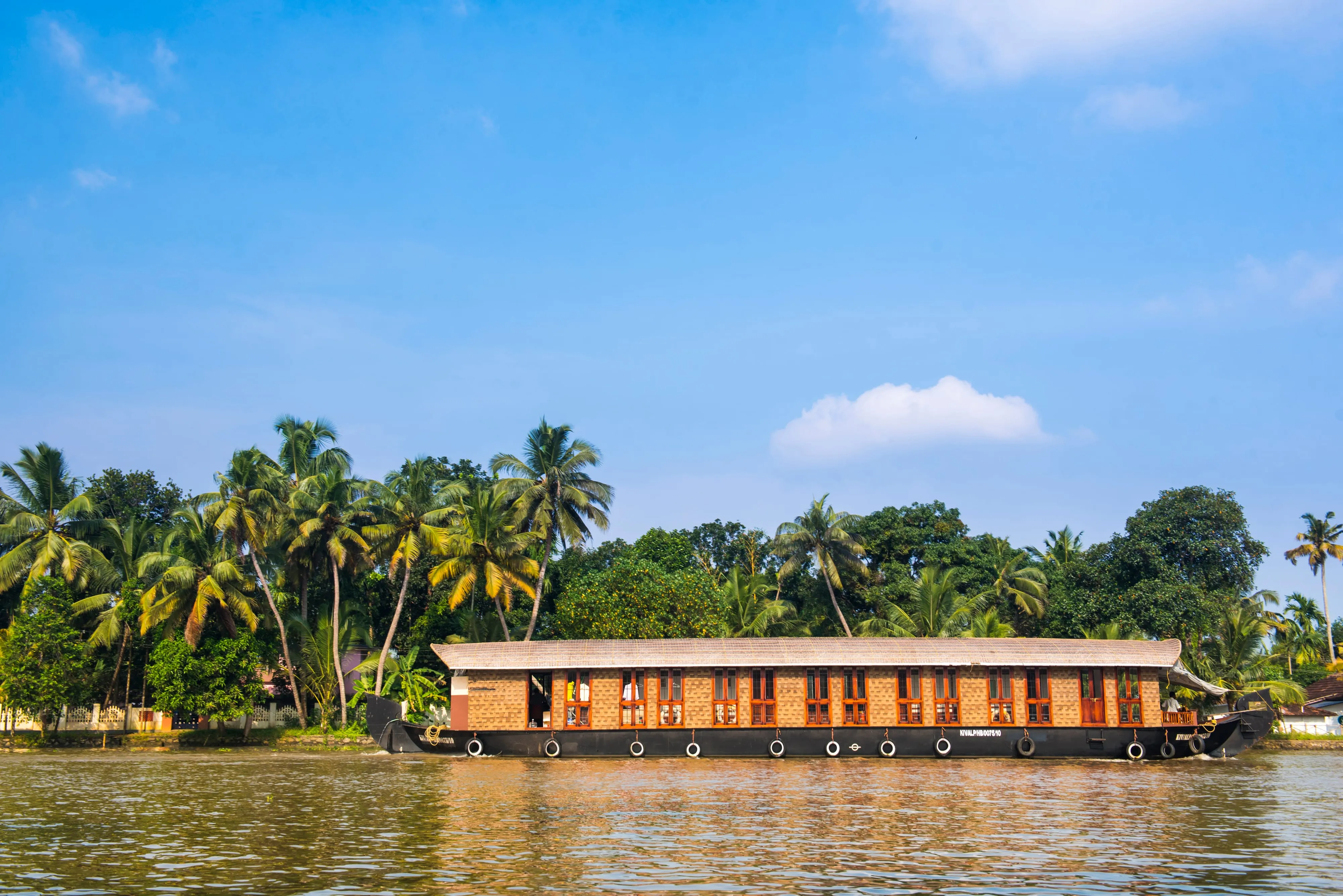 A houseboat gliding through the Kerala backwaters near Alleppey, India